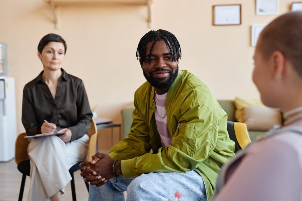 Two people seated and speaking to a counselor.