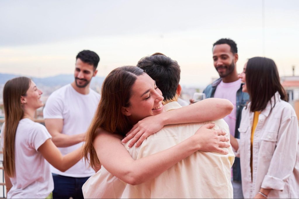 wo people embracing at a social gathering.