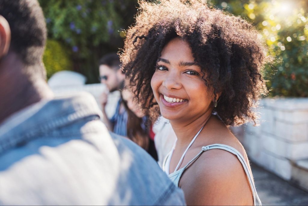 Woman smiling next to people at a party. 