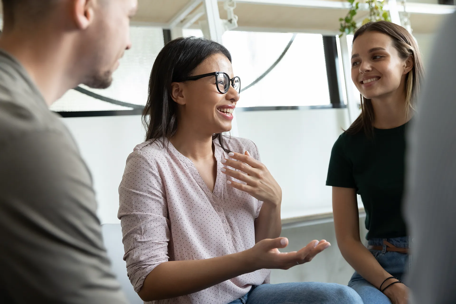 Group therapy session with participants smiling and engaging in discussion